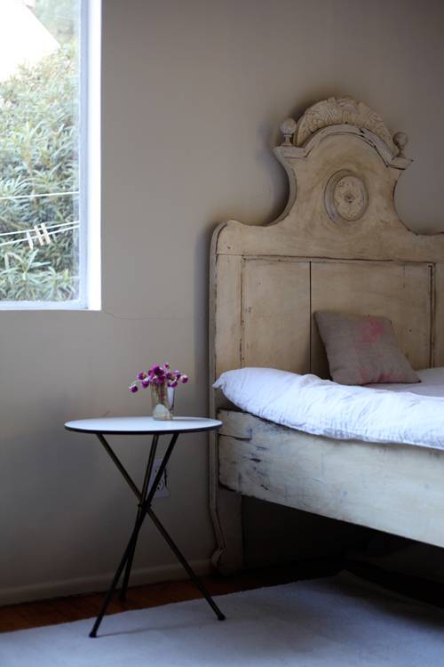 Dormitorio sencillo con cabecero de madera recuperado.