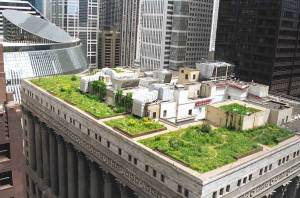 Un jardín de Techos Verdes que florece sobre un edificio urbano, rodeado por el denso paisaje arquitectónico de una ciudad.