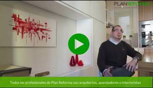 Un hombre está sentado en una habitación moderna con una obra de arte abstracto en la pared roja detrás de él, y un botón de reproducción de video indica que se trata de una captura de pantalla de un video. El texto superpuesto sugiere que está asociado