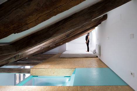 El dormitorio se encuentra en el altillo que se ha construido, junto con la bañera y el tocador.