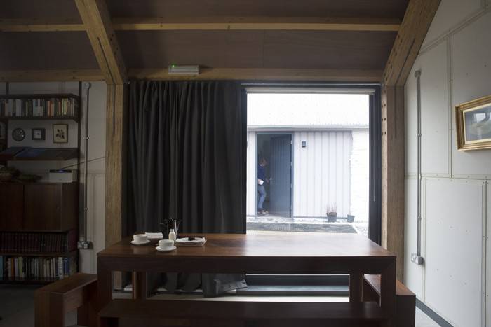 Zona de comedor. La madera oscura contrasta con la gama de grises en la que se basa toda la decoración de la casa-estudio.
