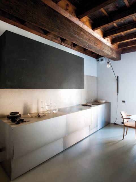 Vista de la cocina, con muebles rectos, minimalistas y una estupenda lámpara Potence de Jean Prouvé de los 50.