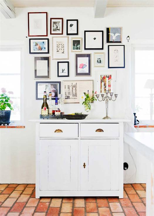 La vivienda tiene detalles diferentes como la colocación de esta alacena en la zona de cocina con la colección de cuadros. Da a este espacio una calidez especial.