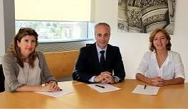 Tres profesionales sentados en una mesa, presumiblemente durante una reunión o conferencia sobre reforman pisos, con papeles delante y una ventana al fondo.