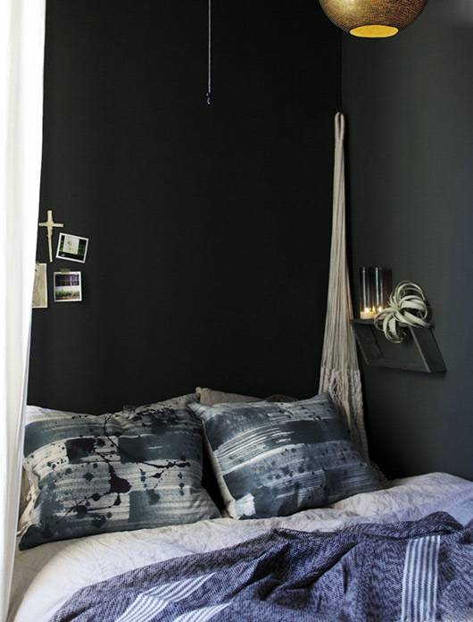 El dormitorio pintado en verde oscuro es muy acogedor.