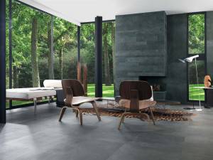 Una moderna sala de estar diseñada por un interiorista, con ventanas de suelo a techo que ofrecen una vista a un bosque. Está amueblada con s