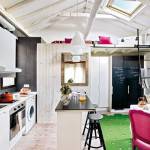 Un diseño de cocinas moderno con interior blanco, destacando vigas de madera a la vista, un tragaluz, una isla central con un taburete negro, armarios.