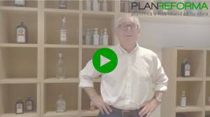 Un hombre con gafas y camisa blanca sonríe frente a un estante con varias botellas, con un gran botón de reproducción superpuesto que indica un video y las palabras "Ulises Plan Reforma".