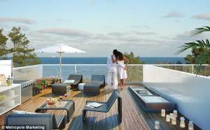 Dos personas en la moderna terraza de la azotea de un hotel con vistas a una zona boscosa, con muebles de exterior, una sombrilla y una parrilla incorporada.