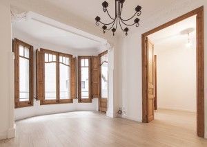 Una reforma por Parramon + Tahull arquitectes transforma la habitación, manteniendo el suelo de madera noble y destacando un techo ornamentado, una lá