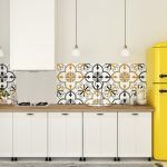 Un interior de cocina moderno con gabinetes blancos, un protector contra salpicaduras de azulejos decorativos y un refrigerador amarillo retro transforma fácilmente su hogar.