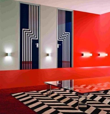 Una habitación contemporánea presentada por un destacado decorador, con un tema de diseño geométrico, paredes atrevidas en rojo y rayadas, tres pu.