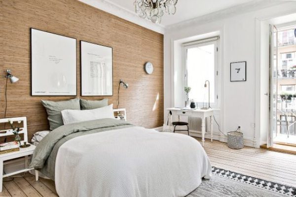 Un dormitorio perfecto, acogedor y bien iluminado que cuenta con una cama con ropa de cama verde, un cabecero de madera, mesitas de noche.