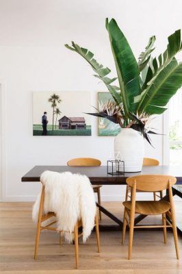 Una estancia moderna para cenar, presentando una mesa de madera con una manta de pelo blanco sobre una silla, rodeada por sillas de estilo mediados del siglo.
