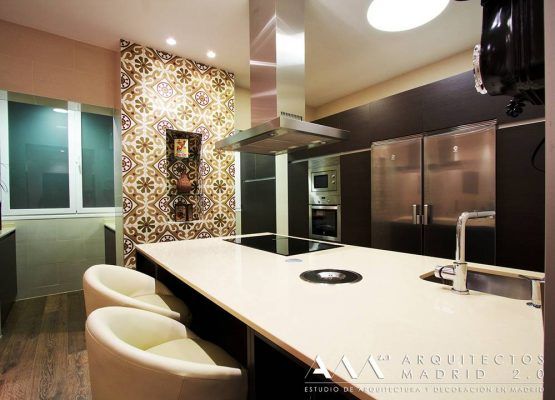 Una cocina moderna con sobres blancos, electrodomésticos de acero inoxidable y mosaicos decorativos en la pared, resaltando un estilo integral de Reforma.