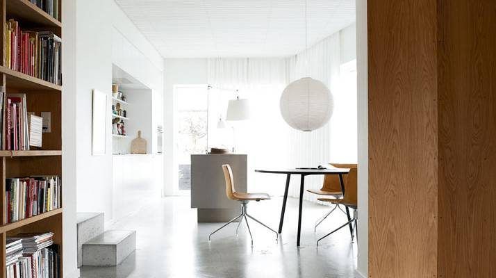 Una moderna área de comedor con decoración minimalista, transformada en un acogedor hogar blanco familiar, presentando una mesa redonda con dos sillas, paredes,