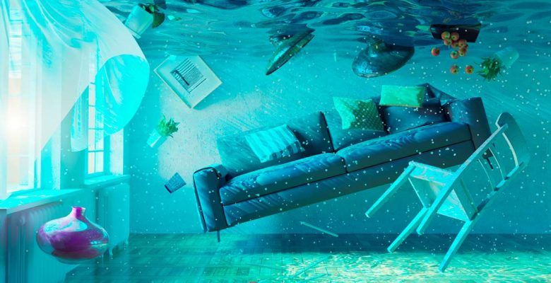Una habitación alterada digitalmente sumergida en agua con muebles y objetos flotando boca abajo, bañada en tonos azules y verdes, sugiriendo una escena submarina de otro mundo para unas vacaciones.